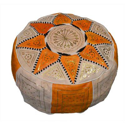 an orange and white round ottoman with decorative designs on the top, sitting in front of a white background