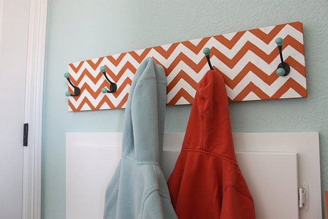 two orange and blue towels are hanging on a coat rack in the corner of a room