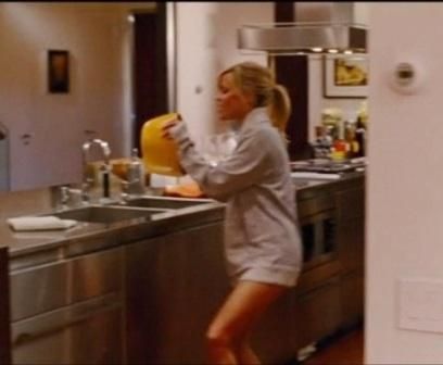 a woman standing in a kitchen next to a sink