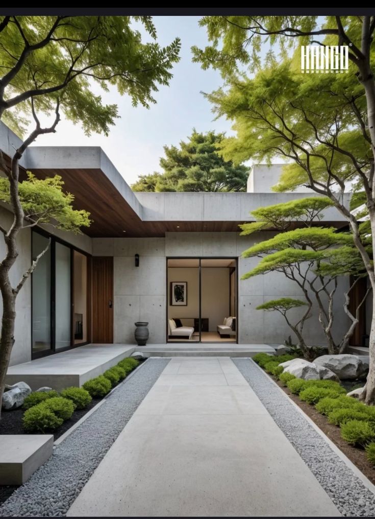 the entrance to a modern house surrounded by trees