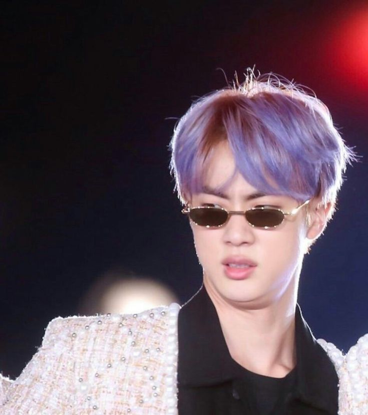 a person with purple hair and sunglasses on