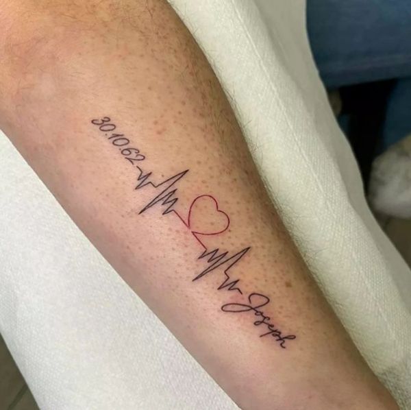 a person with a heart and heartbeat tattoo on their arm