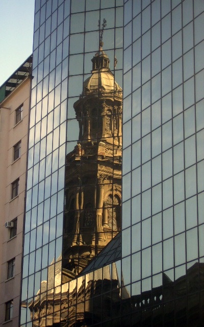 an old building is reflected in the glass windows