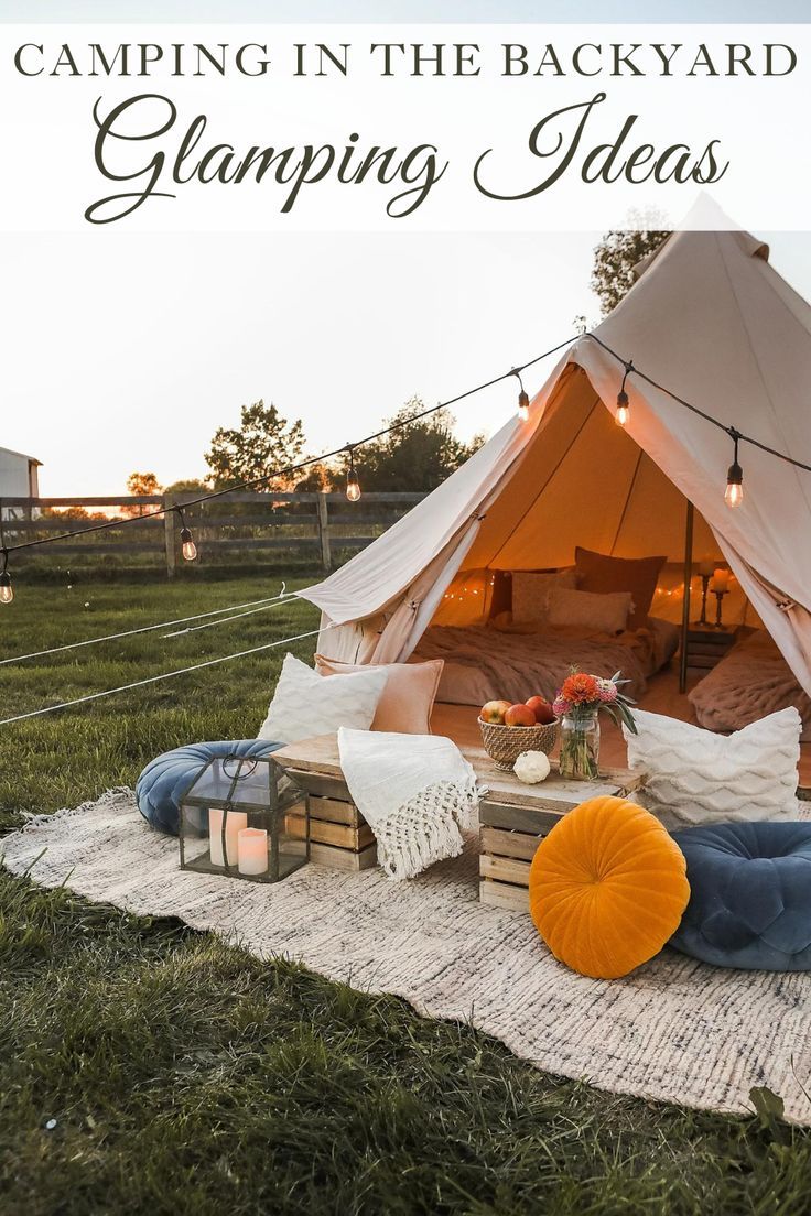 a tent with pillows and lights on the grass