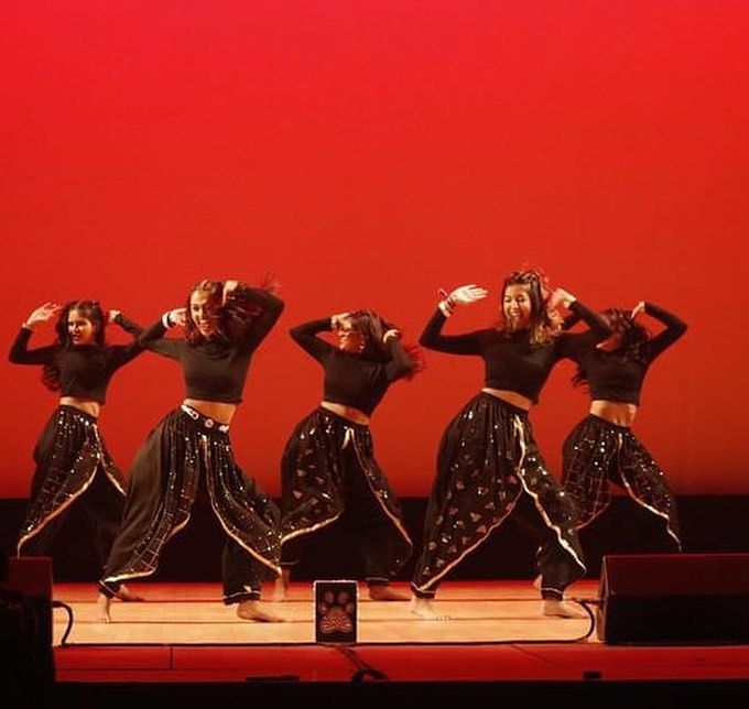 a group of women dancing on top of a stage