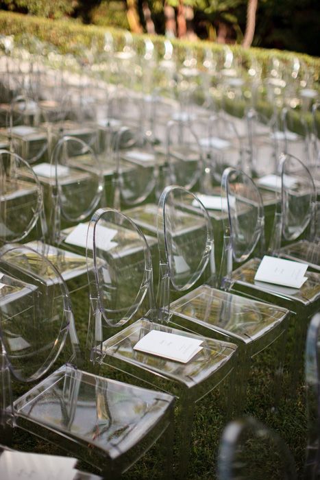 rows of empty wine glasses sitting on the ground in front of some bushes and trees