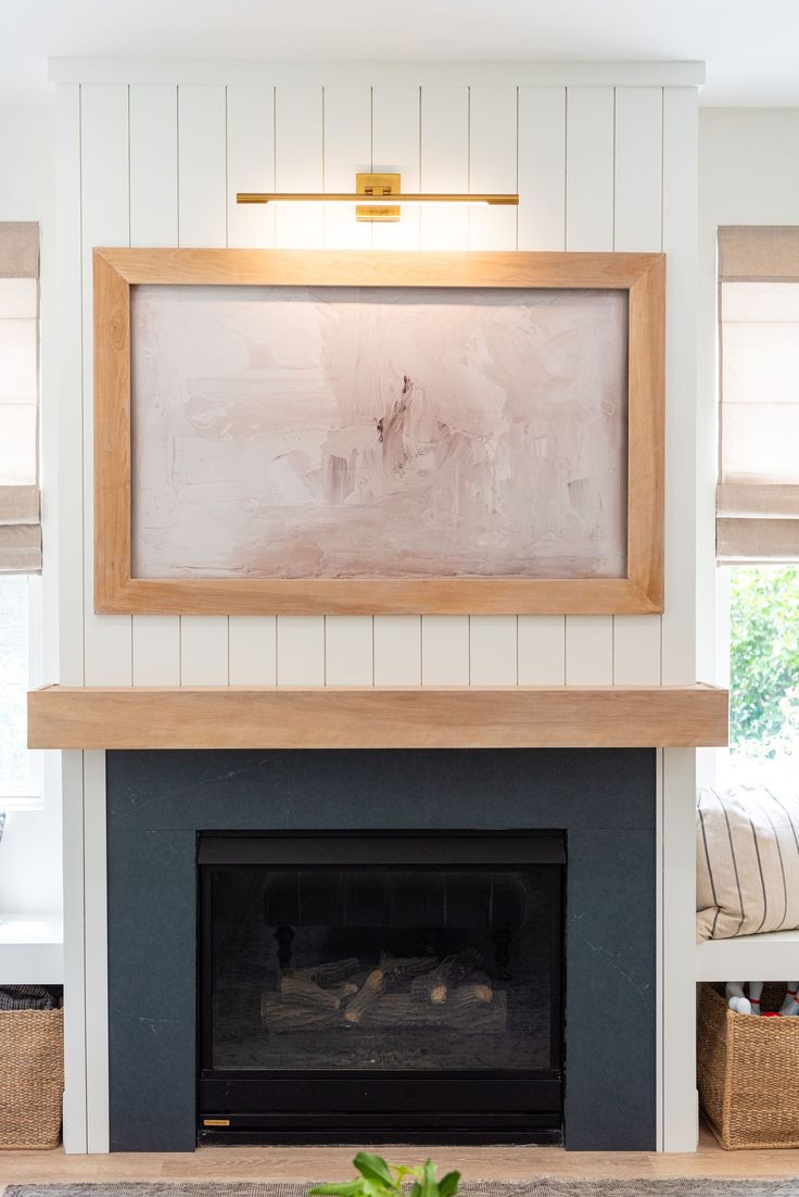 a living room with a fire place and a painting on the fireplace mantel above it