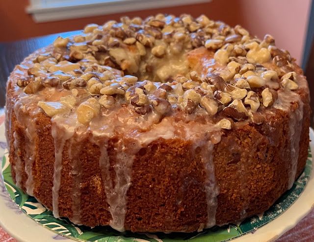 a bundt cake with nuts and icing on a plate