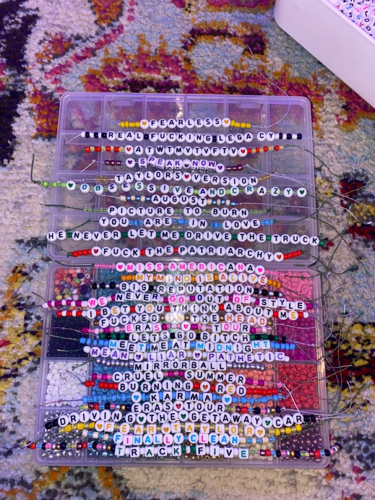 a plastic container filled with lots of different colored beads on top of a rug next to a remote control