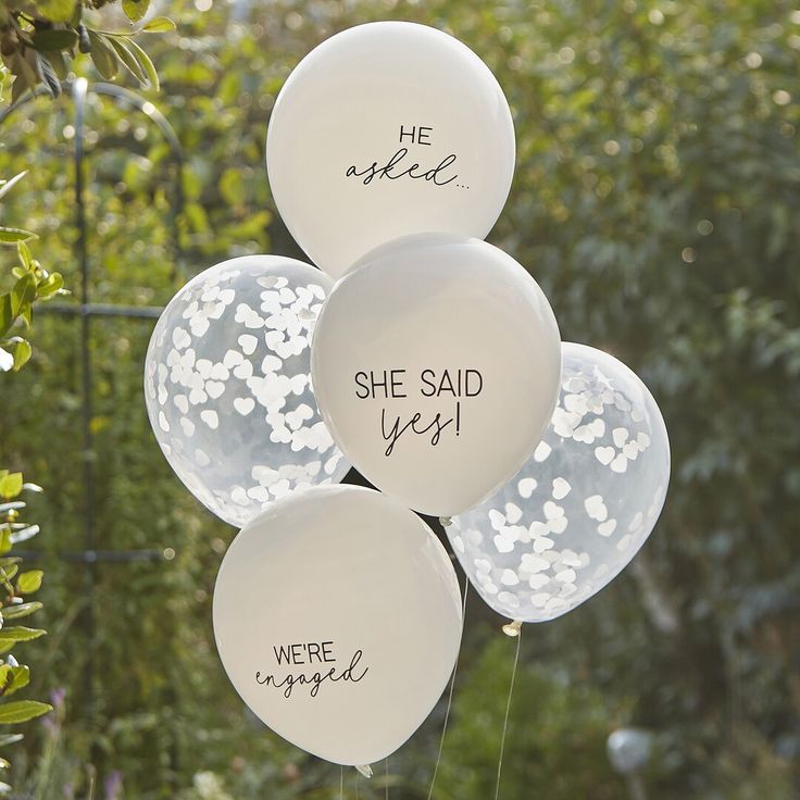 white balloons that say she said yes, we're engaged and he spokee