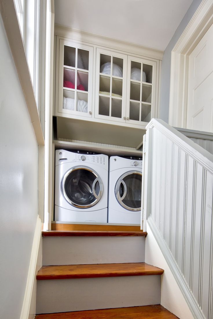 there is a washer and dryer on the stairs in this home laundry room