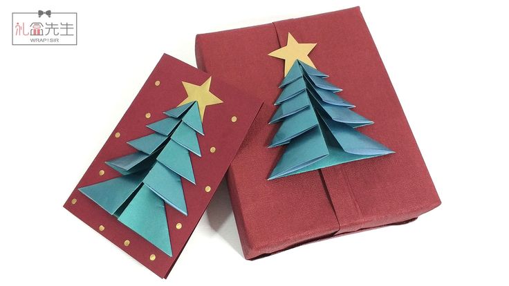 two folded christmas trees on red paper with gold and blue stars in the top left corner