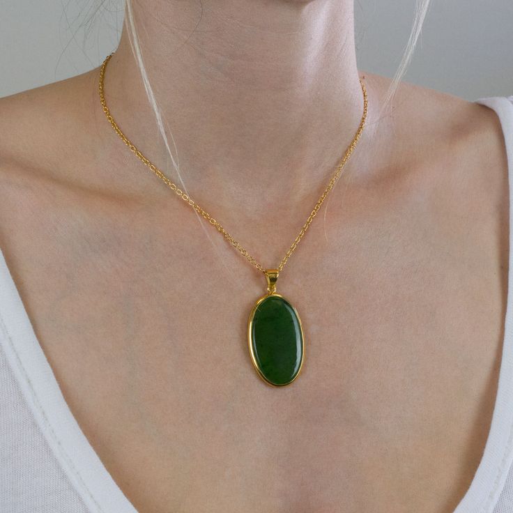 The darker greens in this Nephrite Jade necklace give you more freedom to express yourself. It's a simple neutral gemstone necklace that will brighten your day when paired with other gems. It's all about harmonizing energy with this old, precious crystal necklace. Stone Origin: New Zealand Measures Approximately: 39 x 25 mm Materials: Hand Crafted 925 Polished Sterling Silver with 14k Yellow Gold Vermeil finish and Gold Filled Chain Please Note: If you would like to purchase a different chain pl Green Oval Pendant Necklace For Spiritual Style, Green Oval Pendant Necklace Spiritual Style, Green Necklace With Oval Pendant And Natural Stones, Green Oval Pendant Necklace With Natural Stones, Spiritual Green Oval Pendant Necklace, Jade Oval Pendant Necklace With Natural Stones, Jade Necklace With Oval Pendant And Natural Stones, Green Oval Necklace With Large Stone, Oval Green Necklace With Large Stone