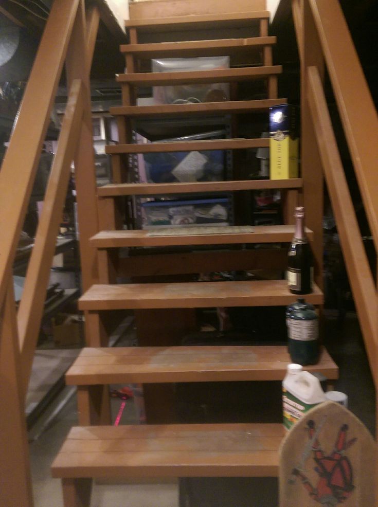 there is a wooden stair case with wine bottles on the top and bottom steps to the second floor