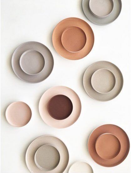 six plates arranged in different colors on a white surface