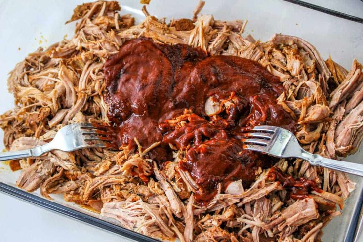 shredded meat with bbq sauce in a glass casserole dish