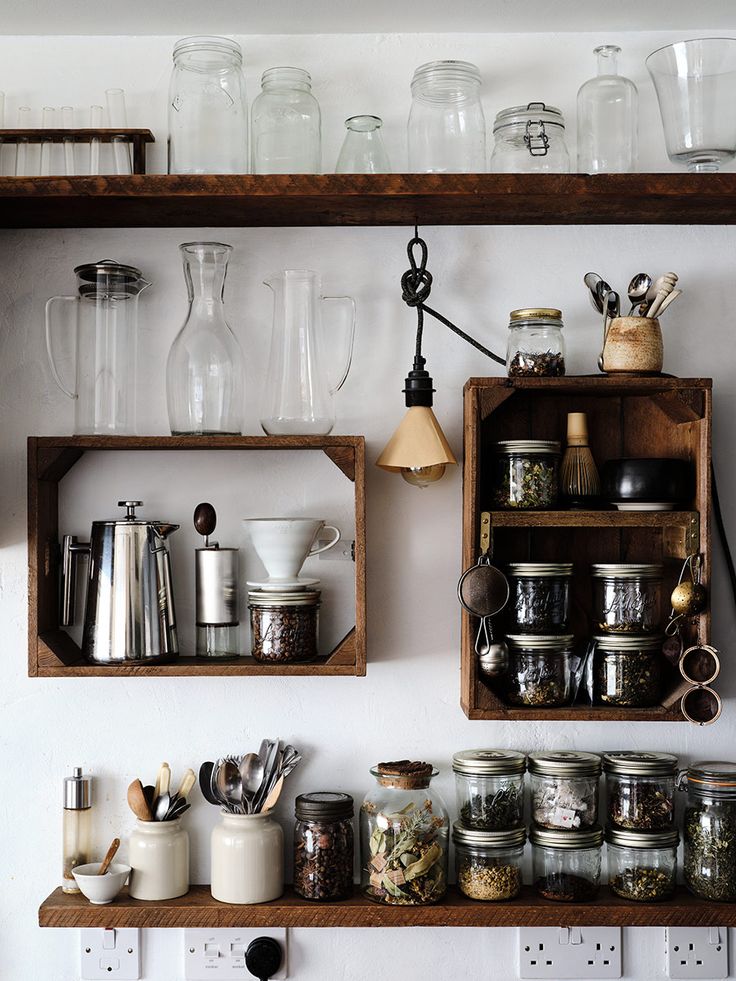 shelves filled with glass jars and other kitchen utensils on top of each other