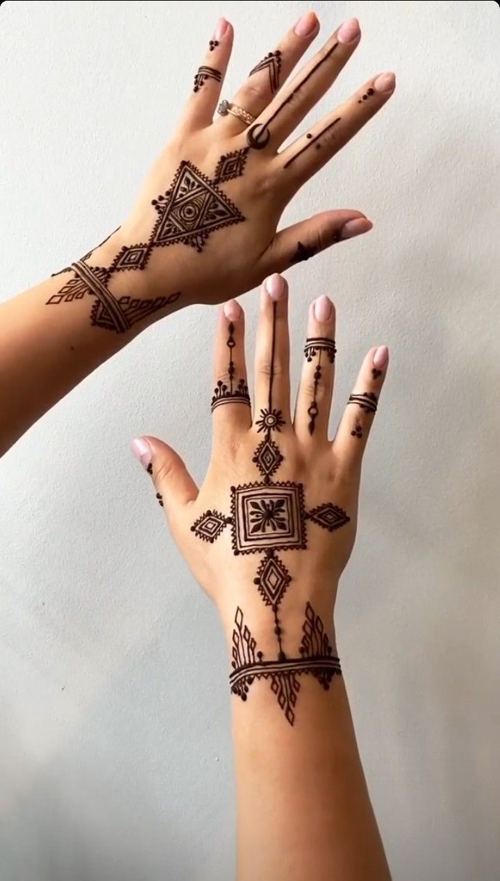 two hands with hendi tattoos on them