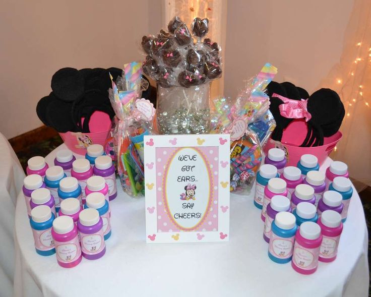 a table topped with lots of bottles and minnie mouse decorations