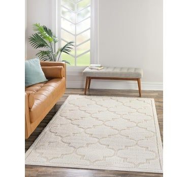 a living room area with a couch, coffee table and rug on the hardwood floor