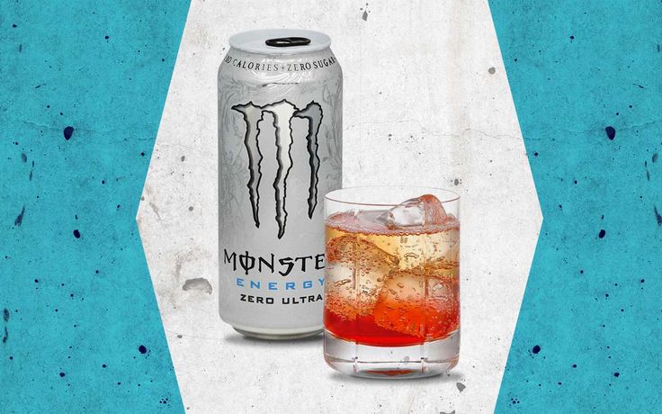 a can of monster energy next to a glass filled with ice