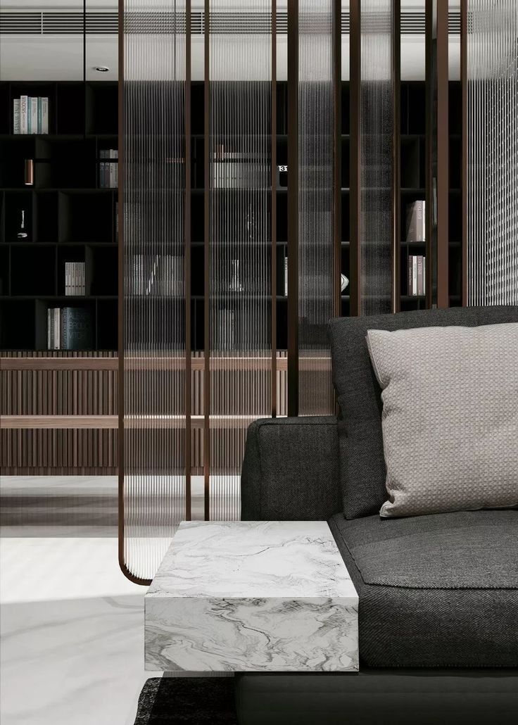 a black couch sitting in front of a book shelf