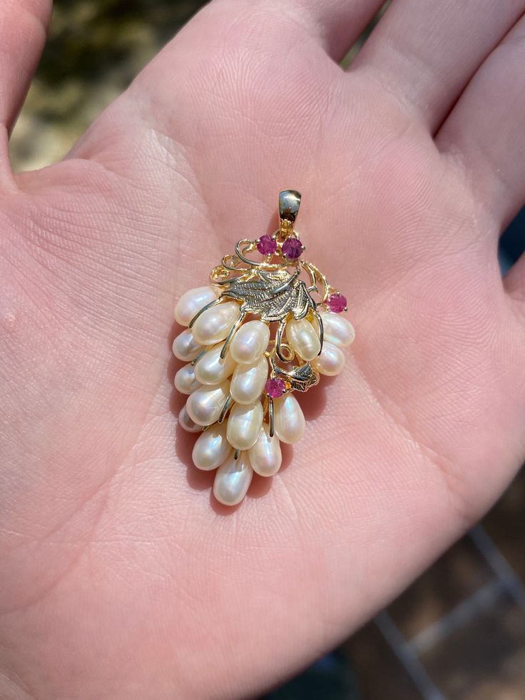 Total Weight: 7.1 grams Length: 34.2m (with bail) Width: 2.3cm Pearl: 6x3.4mm Ruby: 2.5mm Condition: In great condition showing little wear with no damage. All gold has been thoroughly checked with an Olympus XRF spectrometer. It is guaranteed 14k gold.  All our jewelry is properly washed and disinfected to ensure customers get clean items with every order.  Returns accepted but may be subjected to a restock fee.  Please message with any questions:) Exquisite Multi-stone Pear-shaped Jewelry, Gift Jewelry In 14k Gold With High Luster, Exquisite Cluster Jewelry Gift, Exquisite Pear-shaped Multi-stone Jewelry, Luxury Dangle Pearl Pendant Jewelry, Fine Jewelry Pear-shaped Multi-stone, Gold Cluster Fine Jewelry, White Gold Cluster Jewelry Stamped 14k, Heirloom Jewelry With High Luster For Gifts