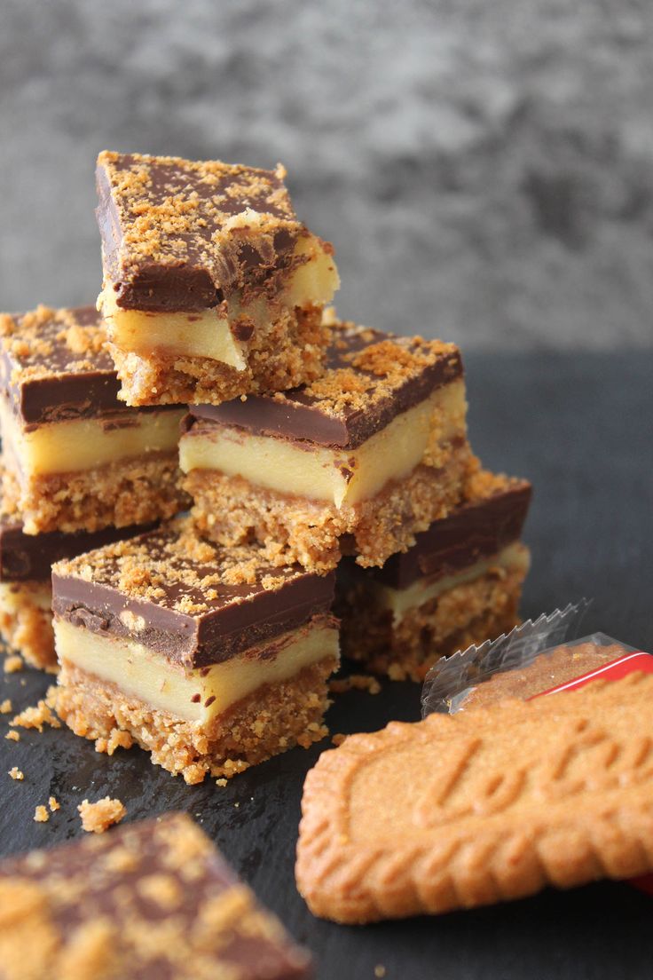 several pieces of dessert sitting on top of a table next to crackers and a cookie