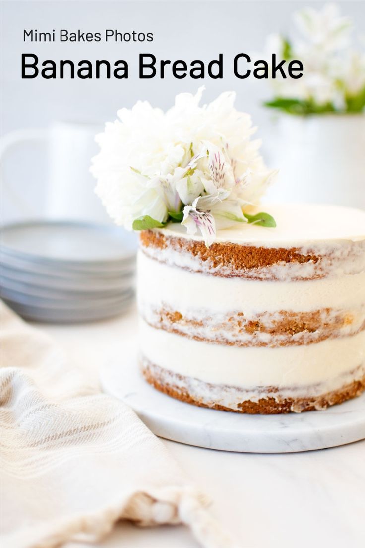 there is a cake with white flowers on top and the words banana bread cake above it