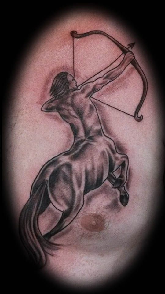 a man with a bow and arrow tattoo on his arm is holding onto a horse