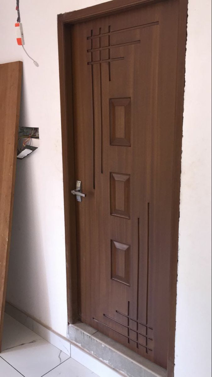 a wooden door in a room with tile flooring