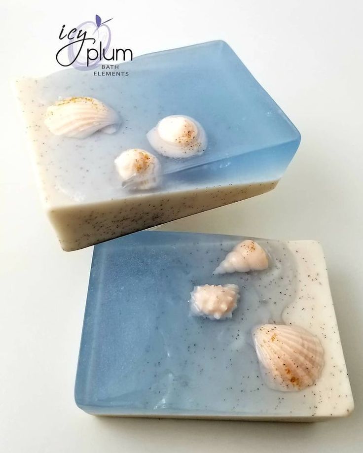 two soap bars sitting on top of each other with sea shells in the middle of them