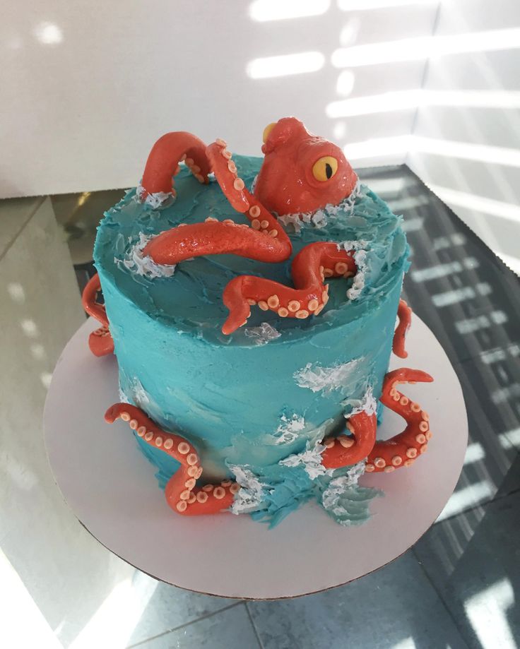 an octopus cake with blue frosting and red decorations