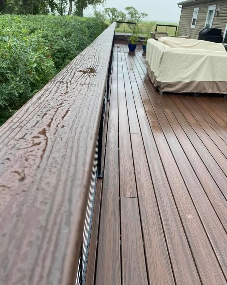 there is a covered couch on the back of a deck in front of a house