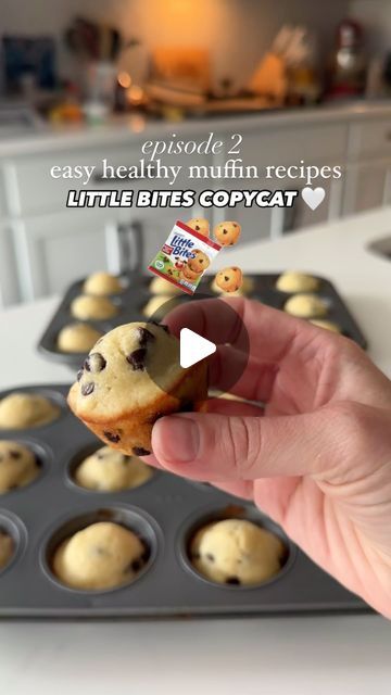 a hand holding a chocolate chip cookie in front of a muffin tin filled with little bites