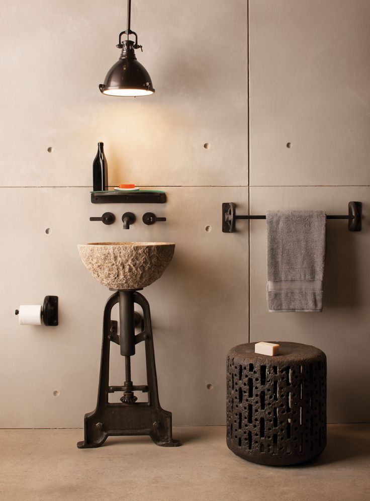 a bathroom with a sink, stool and towel rack on the wall next to it