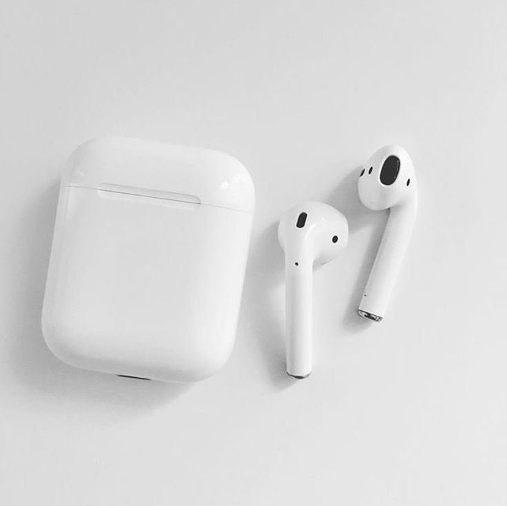 an apple airpods sitting next to another earbud on a white surface,