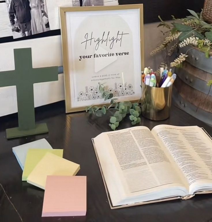 an open book sitting on top of a table next to a cross and other items