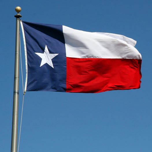 the texas state flag is flying high in the sky