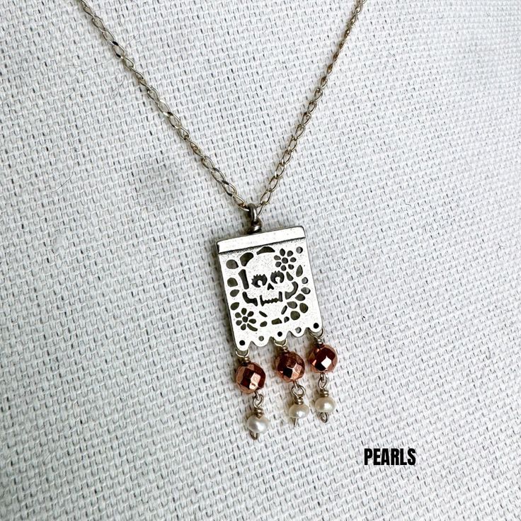 This exquisite Joyeria Plata necklace, featuring a unique Papel Picado pendant, is a masterpiece of Mexican craftsmanship. Handcrafted with meticulous attention to detail, it echoes the rich cultural heritage of Artesanias Mexicanas. The delicate Papel Picado design, a traditional Mexican folk art, is beautifully rendered in silver, making this Taxco necklace a captivating piece of Joyeria Mexicana. Adorned with intricate patterns, it captures the vibrant spirit of celebrations like Cinco de Mayo and Dia de los Muertos. This Mexican silver necklace is more than just an accessory; it's a symbol of Mexican tradition and artistry. With its fine craftsmanship and unique design, it stands out as a stunning representation of Taxco's renowned silverwork. The Papel Picado pendant adds a touch of e Traditional Silver Necklace With Square Pendant, Bohemian Long Necklace With Pearl Pendant, Elegant Handmade Square Pendant Necklace, Silver Brass Necklace With Square Pendant, Silver Dangle Brass Necklaces, Bohemian Sterling Silver Jewelry With Square Pendant, Unique Sterling Silver Filigree Necklace, Traditional Sterling Silver Nickel Free Necklace, Sterling Silver Dangle Necklace For Festivals