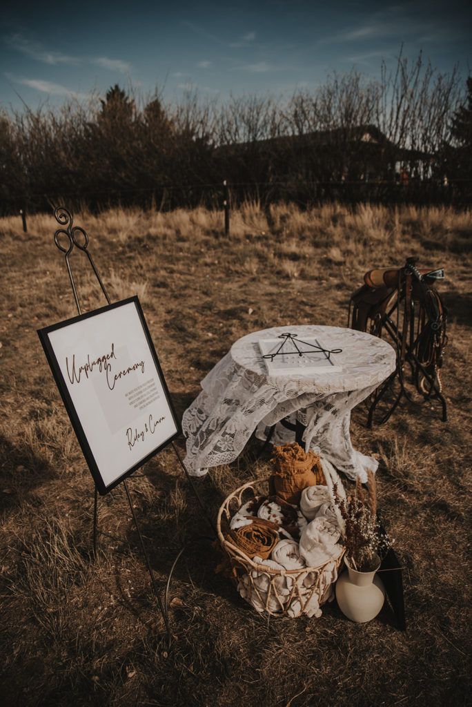 a picnic table set up in the middle of a field with a sign on it