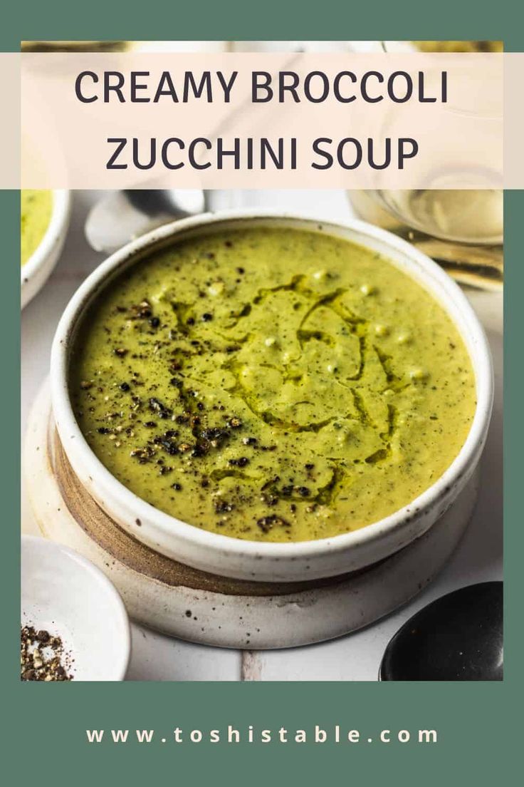 creamy broccoli zucchini soup in a white bowl with spoons on the side