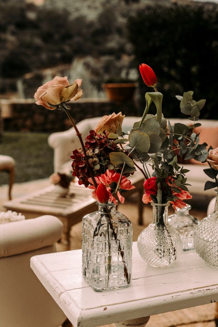 two vases filled with flowers sitting on top of a table