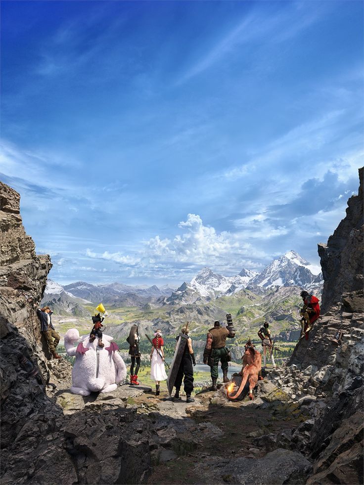 a group of people standing on top of a rocky hill next to a mountain range