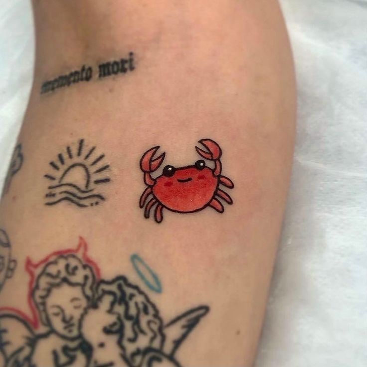 a small crab tattoo on the left leg and right leg with other tattoos around it