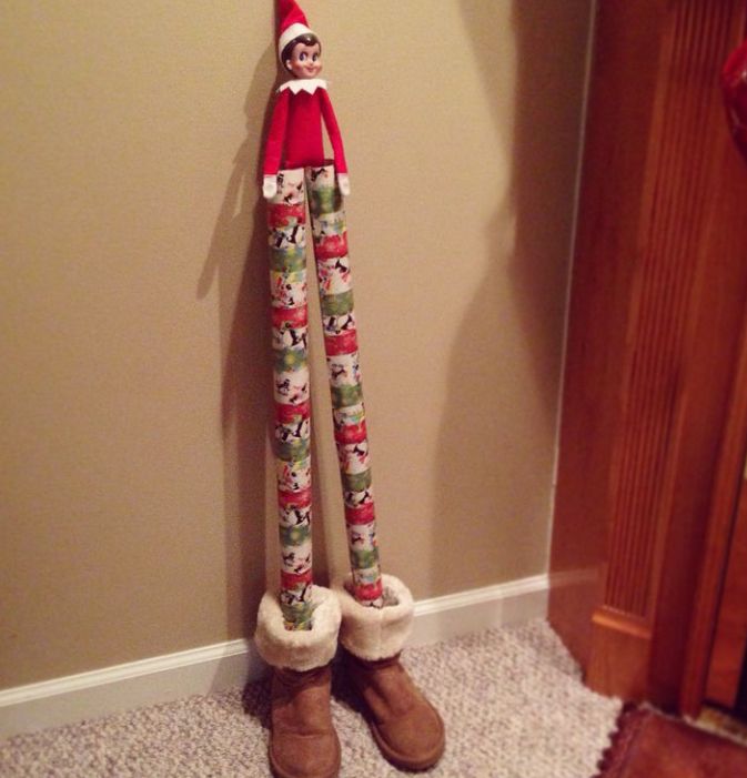 an elf is standing in front of a wall with his legs wrapped around the pole