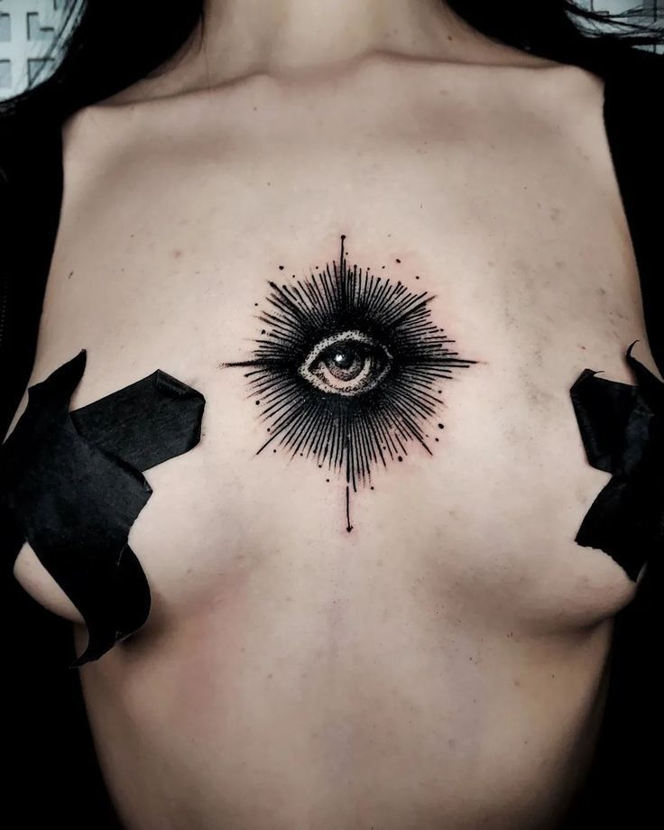 a woman's chest with an eye tattoo on it