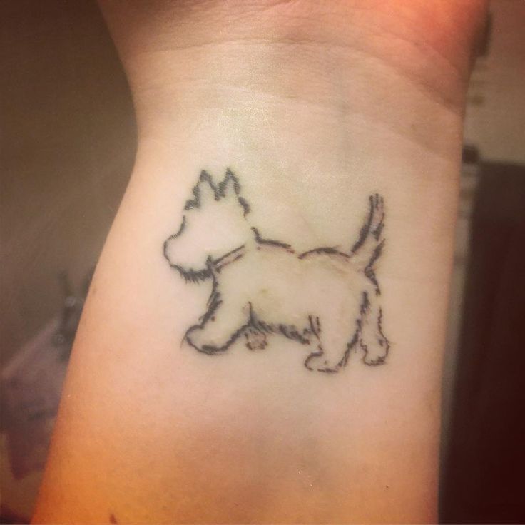 a small black and white dog tattoo on the right side of the wrist, it looks like an outline