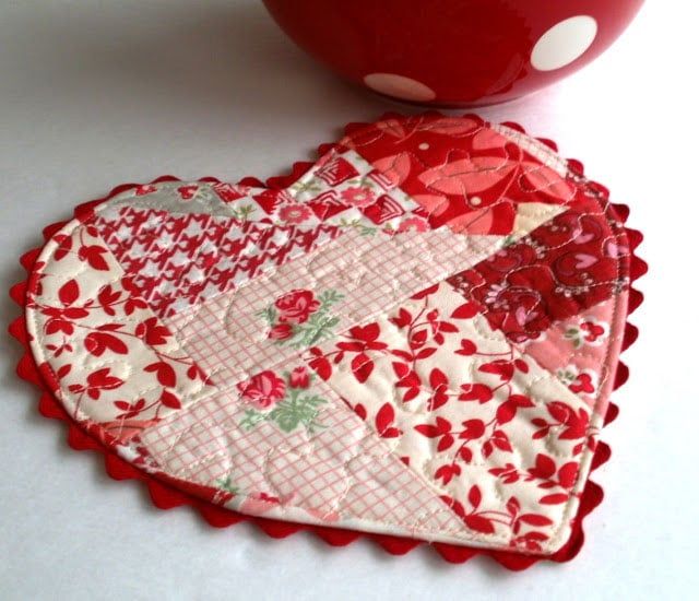 two heart shaped coasters sitting next to a red bowl