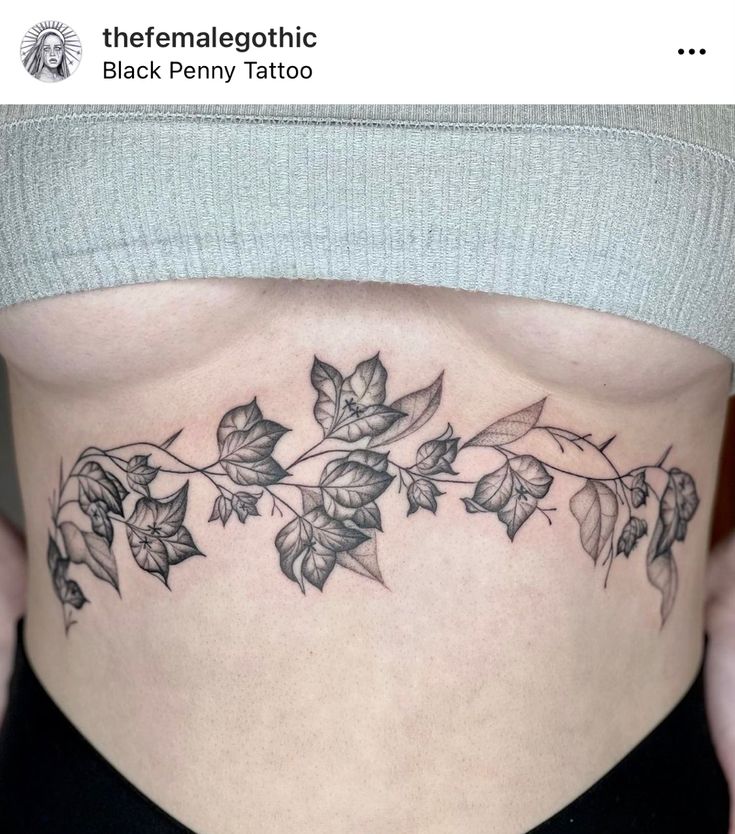 a woman's stomach with leaves and vines tattooed on her side ribcage